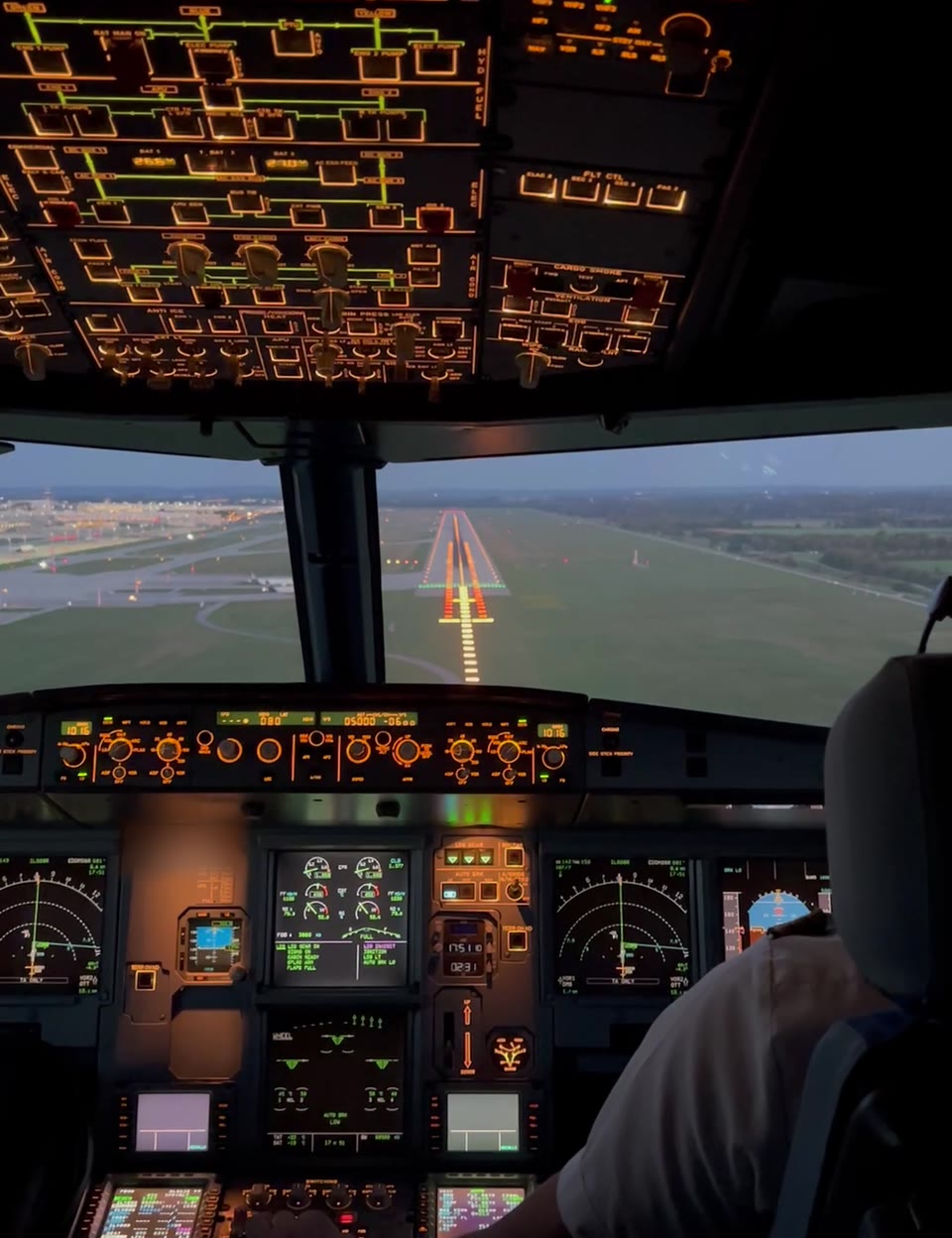 Verkehrsflugzeug im Endanflug mit eingeschalteten Landescheinwerfern in der Dämmerung