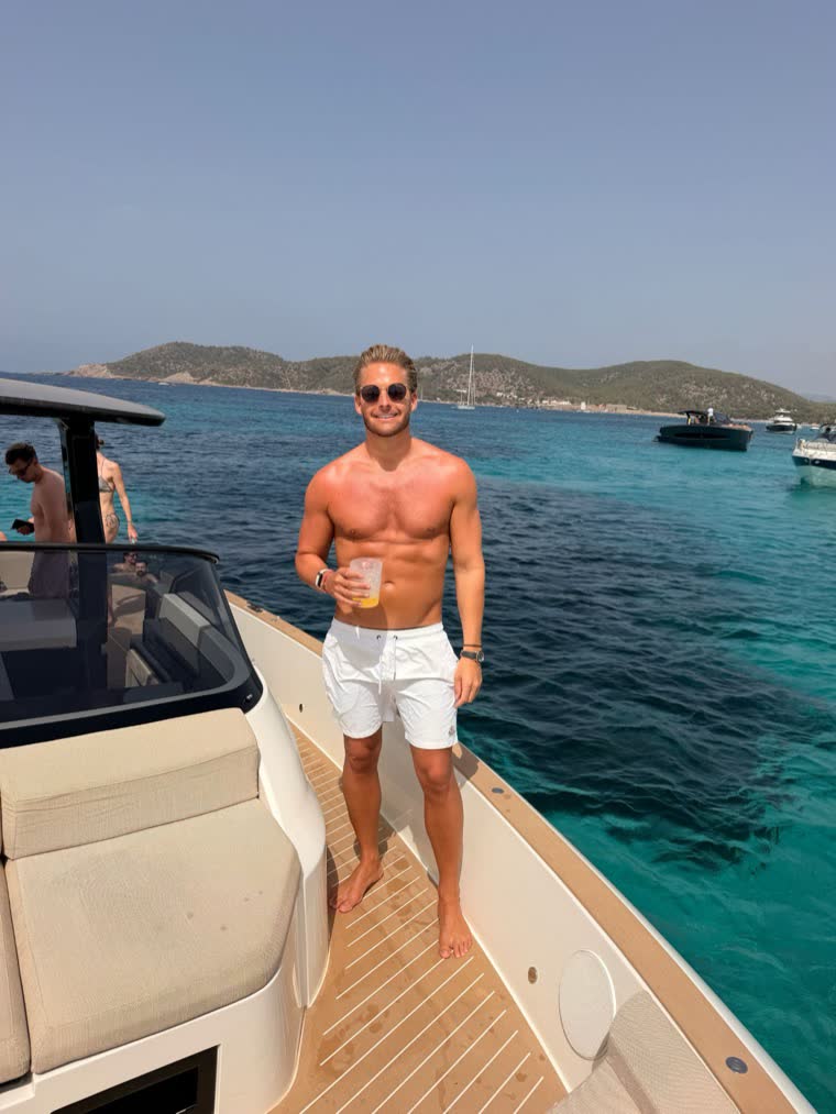 Ben auf dem Vordeck eines Boots vor türkisem Wasser